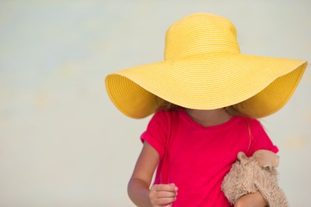 Adorable little girl in hat at beach during summer vacationの写真素材