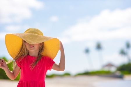 Adorable little girl in hat at beach during summer vacationの写真素材