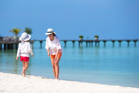 Little happy girl and young mother during beach vacationの写真素材