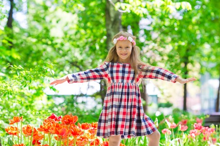 Little beautiful girl in tulips garden at warm spring dayの写真素材