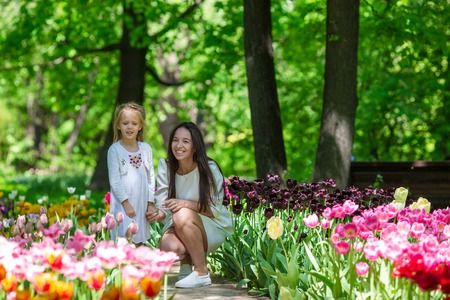 Adorable little girl and young mom enjoying warm day in tulip gardenの写真素材