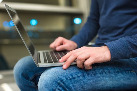 Businessman using laptop or notebook computer while sitting on the chair at the airportの写真素材