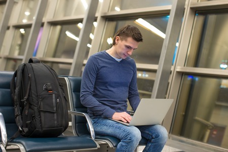 Businessman using laptop or notebook computer while sitting on the chair at the airportの写真素材