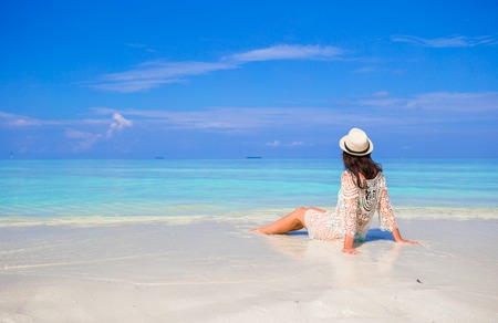Young happy woman enjoy summer vacation on white sandy beachの写真素材
