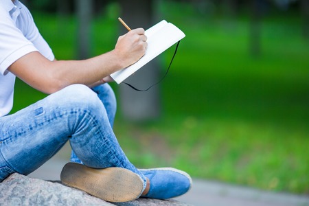 Close up of hands of boy studying for college exam in park outsideの写真素材