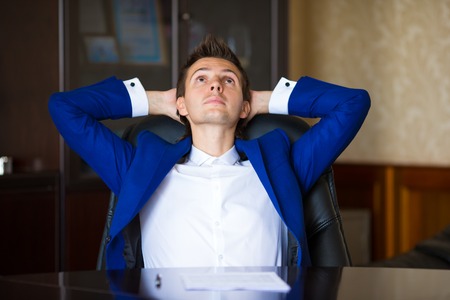 Business man relaxing in his armchair at officeの写真素材
