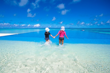 Adorable little girls playing in outdoor swimming poolの写真素材