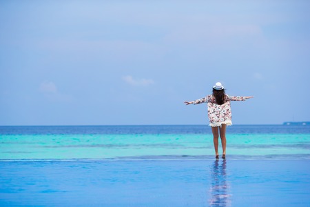 Beautiful young girl relaxing in outdoor swimming poolの写真素材