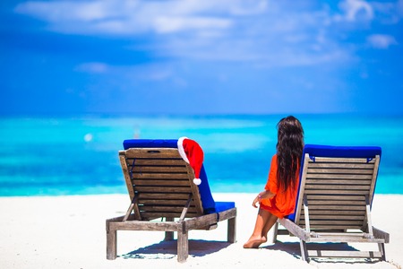 Red santa hats on chair longue at tropical caribbean beachの写真素材