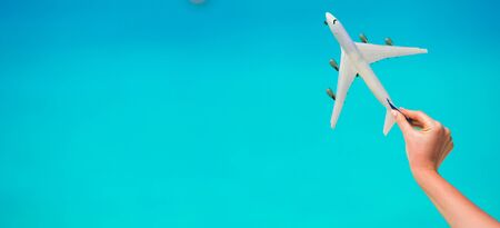 Small homemade plane in a female hand on a background of the seaの写真素材