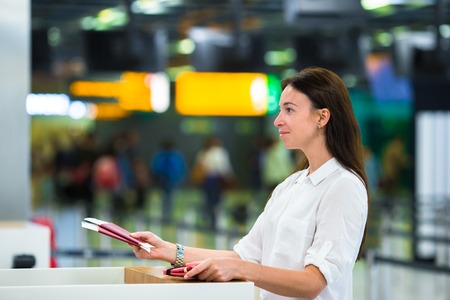 Closeup of female hands holding passports and boarding pass at airportの写真素材