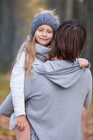 Father with cute daughter in autumn park outdoorsの写真素材
