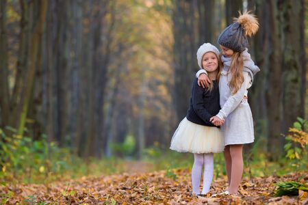 Two adorable girls in forest at warm sunny autumn dayの写真素材