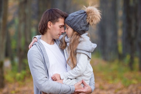 Father with cute daughter in autumn park outdoorsの写真素材