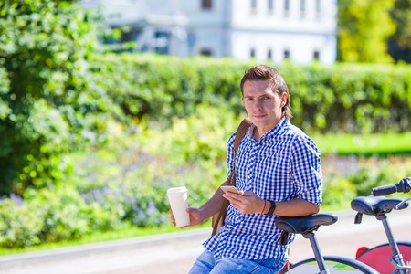 Young boy with a glass of coffee for a walk on the streetの写真素材