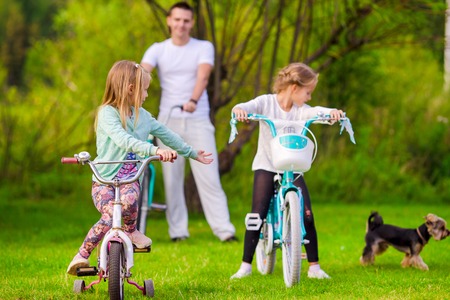 Family of father and kids biking at summer vacationの写真素材