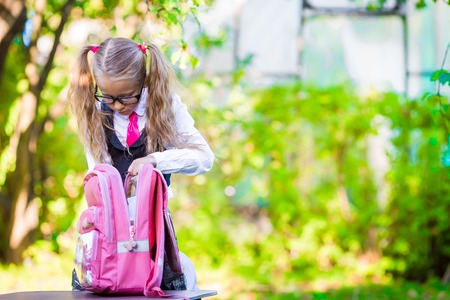Happy little schoolgirl going back to school outdoorの写真素材