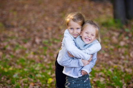 Two adorable girls in forest at warm sunny autumn dayの写真素材