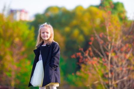 Adorable little girl at beautiful autumn day outdoorsの写真素材