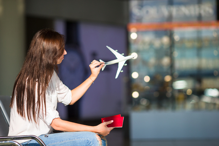 Happy woman with air ticket at airport waiting for flightの写真素材