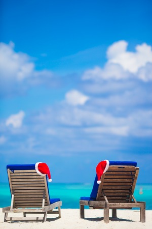 Red santa hats on chair longue at tropical caribbean beachの写真素材