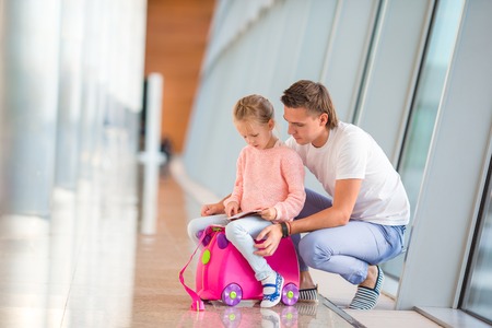 Dad and little daughter looking out the window at airport terminalの写真素材