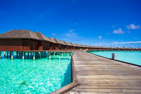 Water bungalows and wooden jetty with turquiose water on Maldives