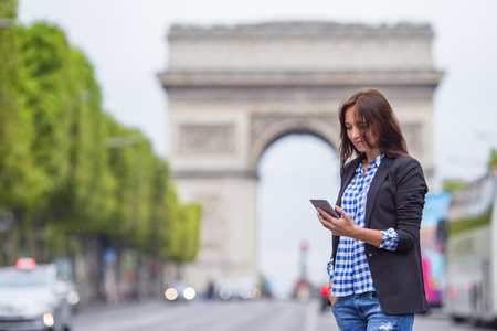 Beautiful woman holding a phone in Parisの写真素材