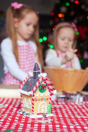 Little girls baking gingerbread cookies for Christmas at home kitchenの写真素材
