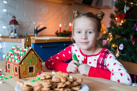 Happy adorable girl baking Christmas cookies at homeの写真素材