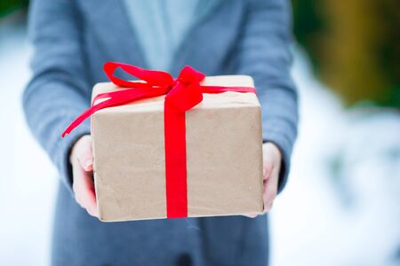 Woman with christmas box gift in winter day