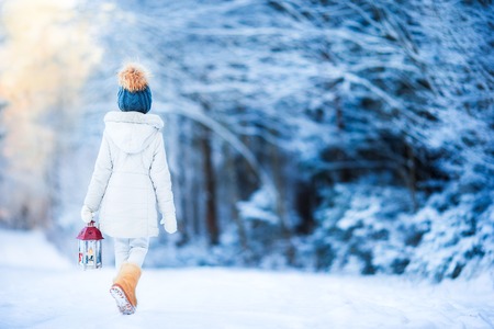 Cute little girl with flashlight having fun in winter dayの写真素材