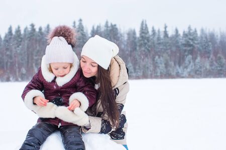 Happy family playing snowballs in the winter snowy day
