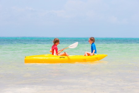 Little cute girls kayaking in the clear blue seaの写真素材