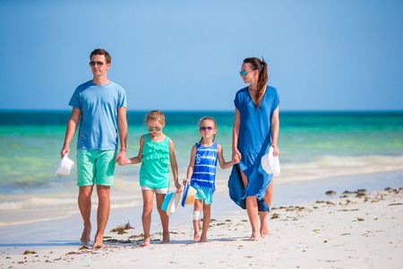 Happy beautiful family on white beach having funの写真素材