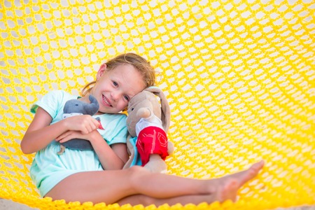 Adorable little girl swinging in hammock at beachの写真素材
