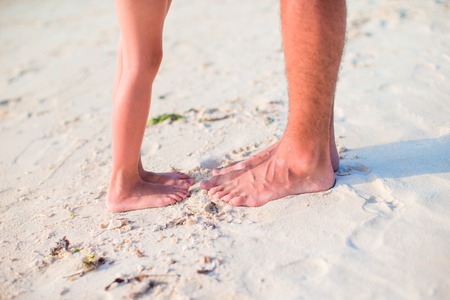 little girl with feet at the white sandy beachの写真素材