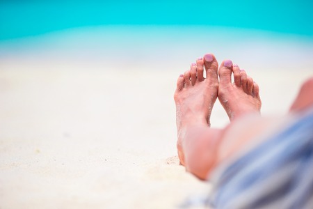 Close up of female feet on white sand beachの写真素材