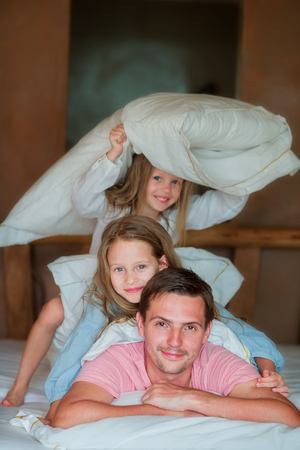 Man with two young children sitting in bed smilingの写真素材