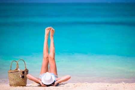 Young beautiful woman relaxing at white sand tropical beachの写真素材