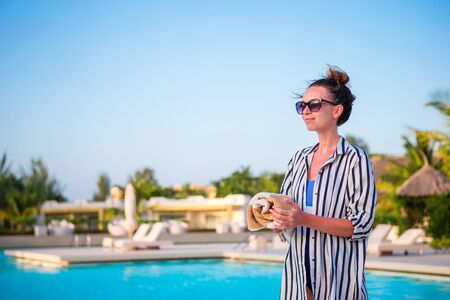 Beautiful young woman relaxing near the swimming pool