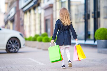 Adorable smiling little girl with shopping bags outdoorsの写真素材