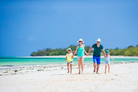 Happy beautiful family on white beach having funの写真素材