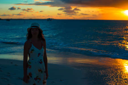 Beautiful woman in white dress enjoying sunset