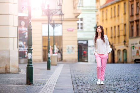 Girl caucasian drinking hot drink coffee walking in street at Europeの写真素材
