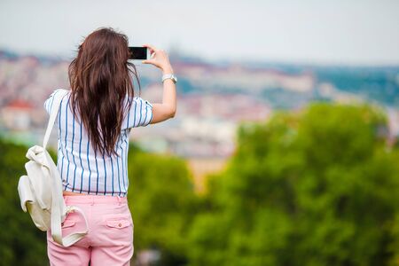 Young caucasian woman making photo by mobile phone from the observation placeの写真素材