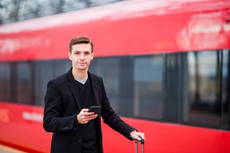 Young man with luggage on the platform waiting for aeroexpressの写真素材