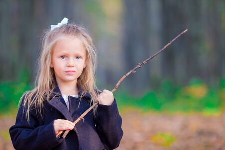 Adorable little girl at beautiful autumn day outdoorsの写真素材