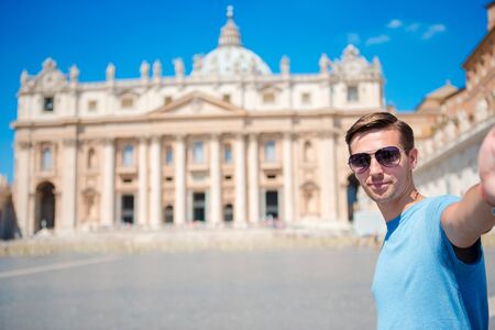 Happy man taking selfie in Vatican city and St. Peter's Basilica church, Rome, Italyの写真素材