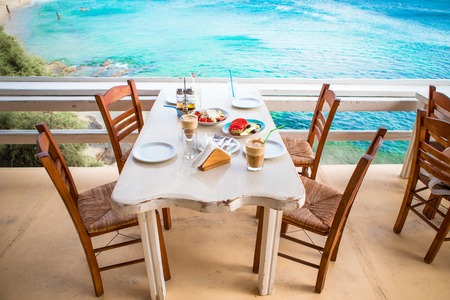Delicious fresh greek salad and musaka served for lunch at outdoor restaurant with beautiful view on...